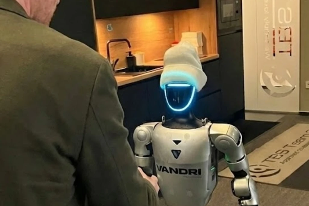 Roland Obermair shaking hand of Jože, the humanoid robot